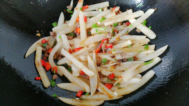 牛肉筷子萝卜,最后调入适量生抽、胡椒和鸡精炒均匀,洒葱花起锅装盘,将剩下的另一半牛肉丁倒在上面即成。