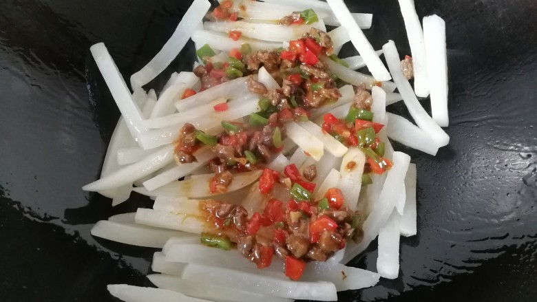 牛肉筷子萝卜,再将炒好的牛肉丁倒一半进去炒均匀;