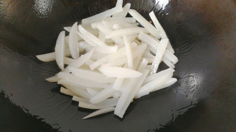 牛肉筷子萝卜,将锅洗净,调入适量油,下萝卜条炒几下;