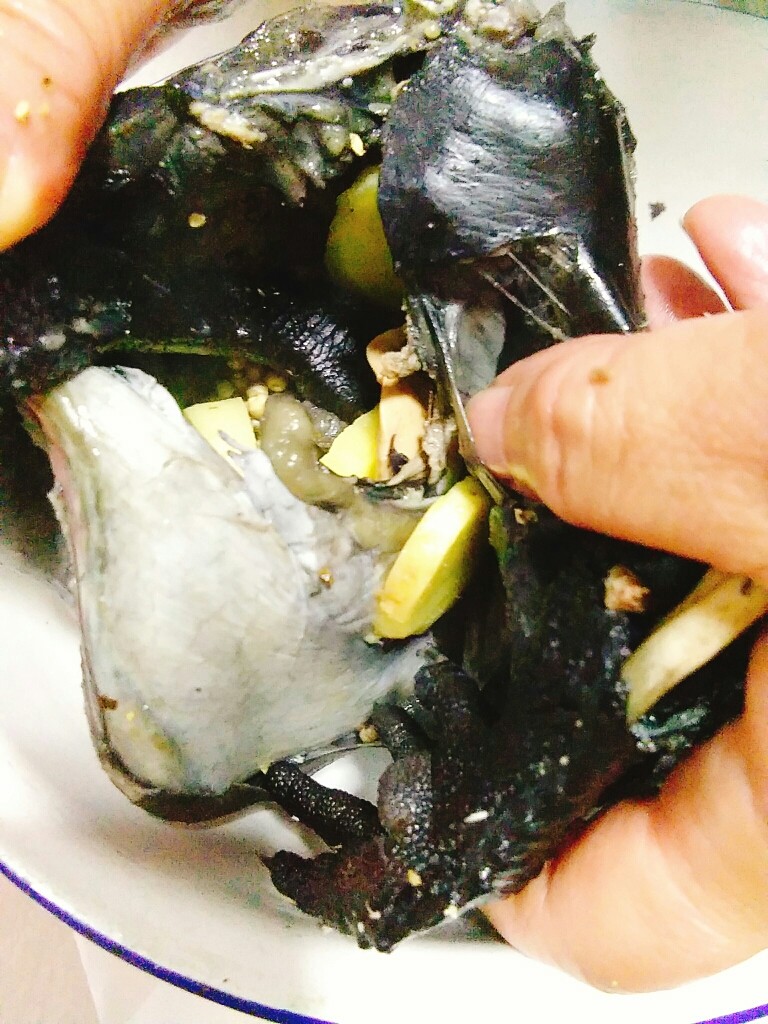 家常养胃荤菜 肚包鸡,把白胡椒粒,5片大姜片塞入鸡肚子里。