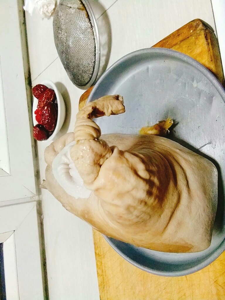 家常养胃荤菜 肚包鸡,捞出来的猪肚鸡已经定型了,等他不烫手了,拆掉牙签,从侧面刨开猪肚。