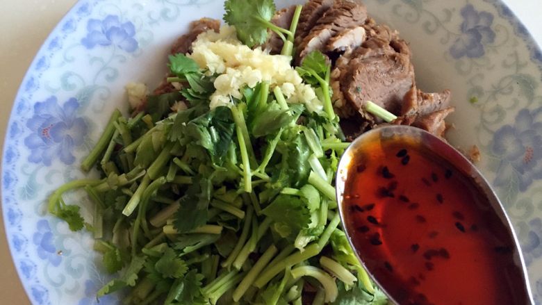 凉拌牛肉,牛肉、香菜和大蒜末放盘中,加入<a style='color:red;display:inline-block;' href='/shicai/ 852'>辣椒油</a>。