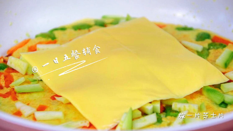 蔬菜奶酪米饭煎饼 宝宝辅食,鸡蛋+毛豆+西葫芦+胡萝卜,翻面后撒西葫芦丁,放一片芝士片。没有这样的芝士片,放宝宝奶酪或者马苏里拉都可以。
