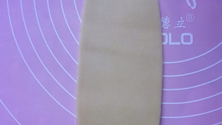 芝麻咸酥饼,取其中一份剂子,用擀面杖擀成牛舌状。