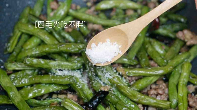 干煸四季豆,放入炸好的四季豆,加盐、鸡粉快速炒15至20秒,即可出锅。