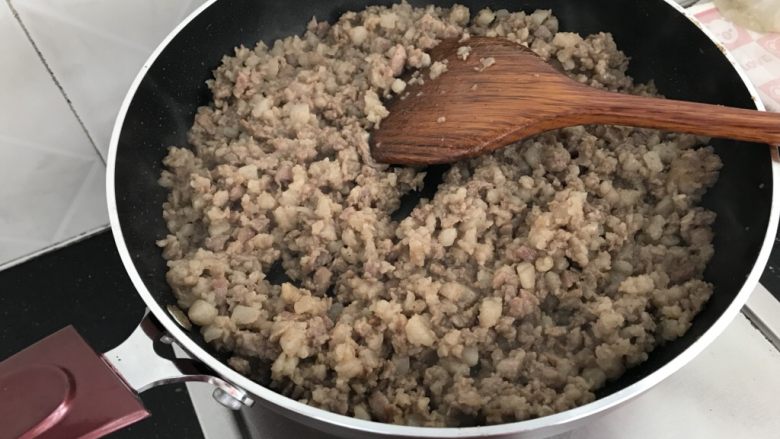 中式点心~猪肉香菇木耳粉丝包,不粘锅里把肉放入炒制,变色出油时