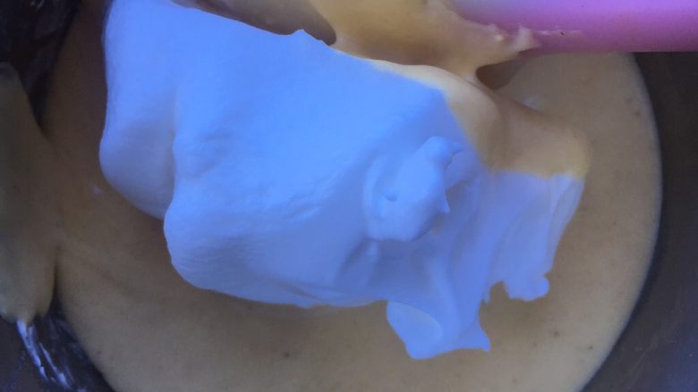 奶酪戚风蛋糕,挖一勺蛋白到蛋黄糊里,翻拌均匀