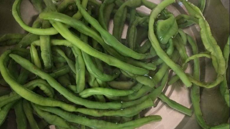 豆角猪肉包,豆角焯熟后捞出,放入凉水中过凉。