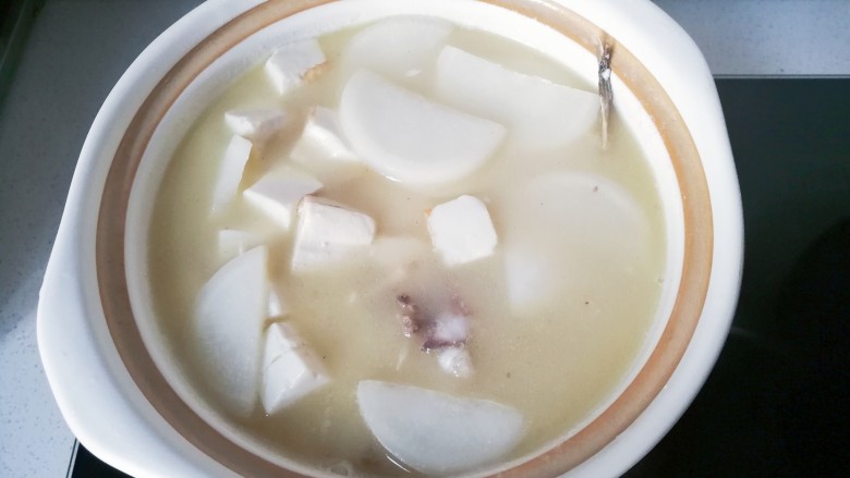 豆腐萝卜鱼头汤,烧开后将鱼头汤全部倒入砂锅中,再小火炖煮;