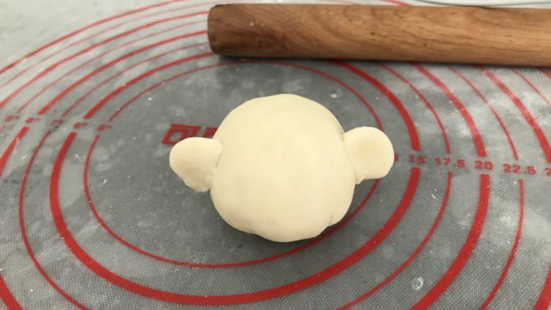 中式点心~自创猪仔包之“猪出没”,收口朝下,搓2个小小圆球,大拇指和食指捏出耳朵状,沾点水粘左右两边