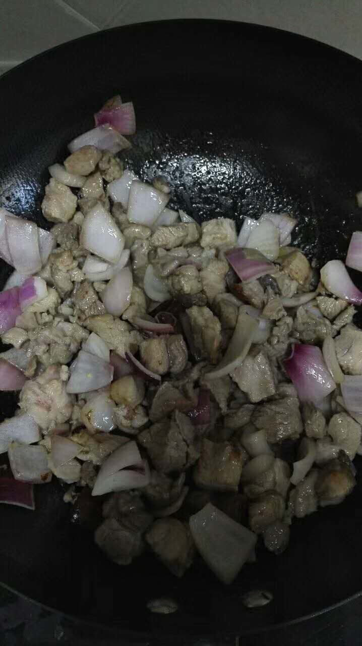 孜然羊肉粒,羊肉煸炒至变色,加少许盐。不断翻炒,羊肉自身的油也会煸炒出来。