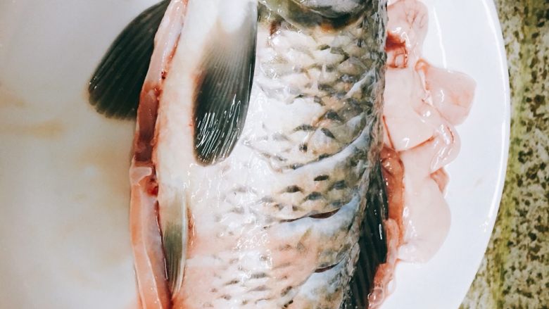 红烧鲤鱼,鱼改花刀后均匀的涂抹盐和料酒,腌渍十五分钟左右