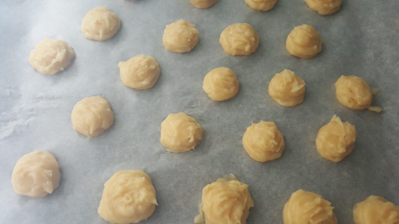 乳酪泡芙(gougères)(法语),将小面团分开摆好在烤盘上。