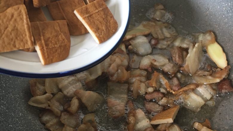  黑酱油+豆干炒肉,加入豆干翻炒均匀