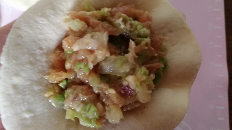 中式点心+钱袋白菜肉包,拿一个擀好的包子皮儿,放入馅,