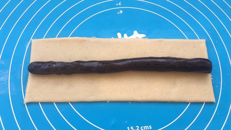 玫瑰豆沙一口酥,玫瑰豆沙用手揉搓成长条,放在面团中间。