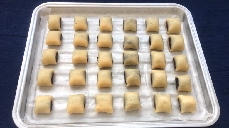 玫瑰豆沙一口酥,烤盘垫上油纸,整齐摆放在烤盘上。
