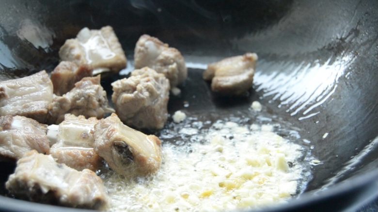 排骨豆角焖面,翻炒至两面金黄,倒入蒜末、姜末,翻炒一会