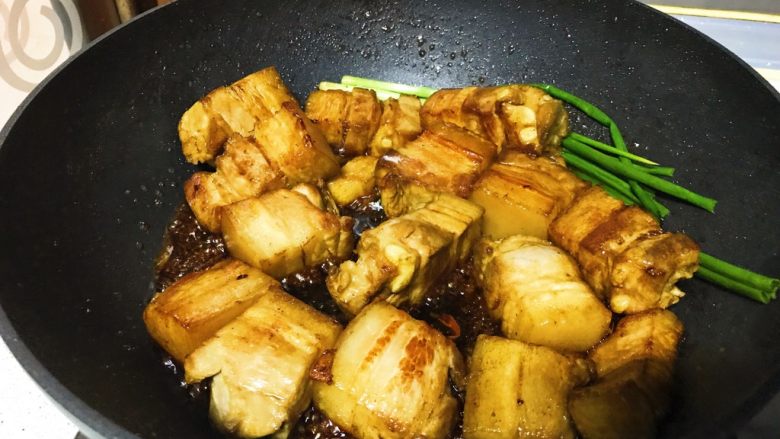黑酱油+腐乳红烧肉,倒入五花肉,翻炒,此时,下葱,<a style='color:red;display:inline-block;' href='/shicai/ 866'>冰糖</a>,草果,八角,小茴香,桂皮,黑酱油闪亮登场,继续翻炒。黑酱油不可贪多,要颜色美丽,渐渐加入,不断翻炒,酒红色就可以了。