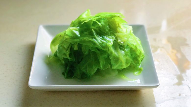 蚝汁蒜香卷心菜,捞到盘里备用,如盘里有水渗出来,需倒掉