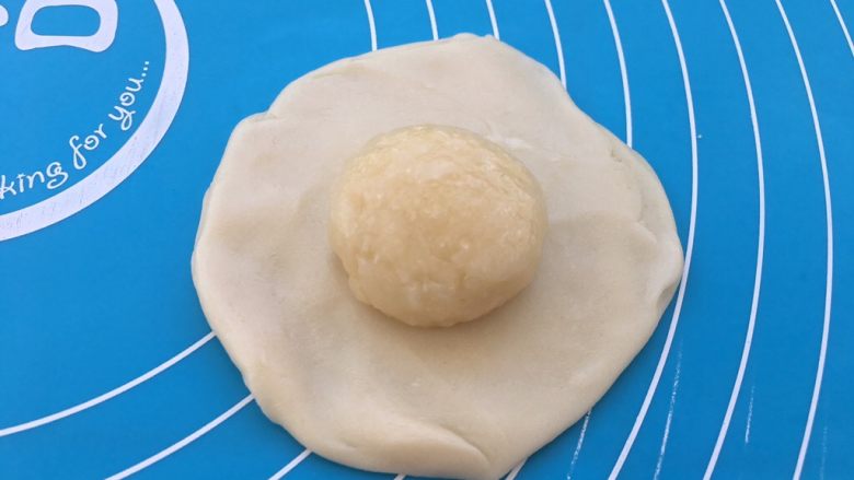 老婆饼,用擀面杖擀成面皮,把之前裹好的馅料放入面皮中间。