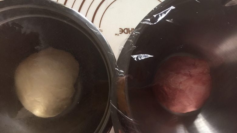 双色水立方吐司面包,再面包机还剩下五分钟时按下暂停键
取出面团排气分割成两份,其中一份加入红曲粉揉匀后分别盖保鲜膜发酵