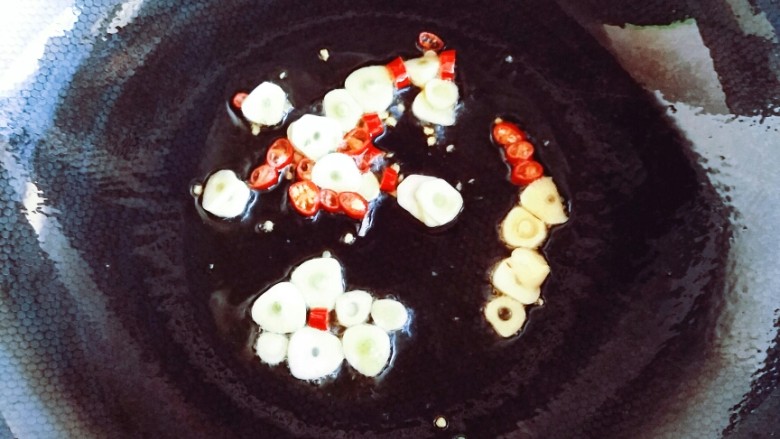 耗油蒜蓉茼蒿,热锅热油,放入红尖椒碎大蒜碎小火炒香。