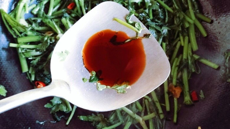 耗油蒜蓉茼蒿,茼蒿受热变软,出水,放入少许耗油和生抽继续翻炒。