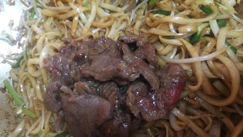 地方菜 干炒牛河,最后倒入炒过的牛肉片,翻炒片刻.