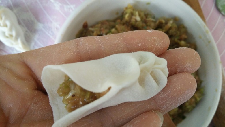 麦穗饺子,从面皮的一头竖着,大拇指和食指分别捏成图中样子