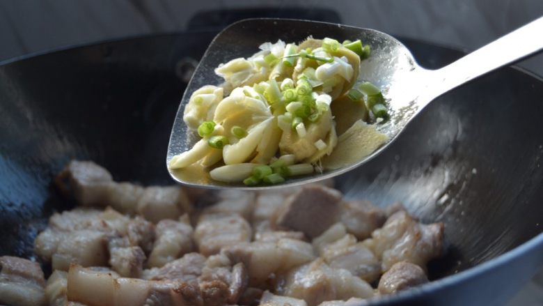 秘制红烧肉,翻炒至表面金黄,加入姜、蒜、葱头,煸炒出味