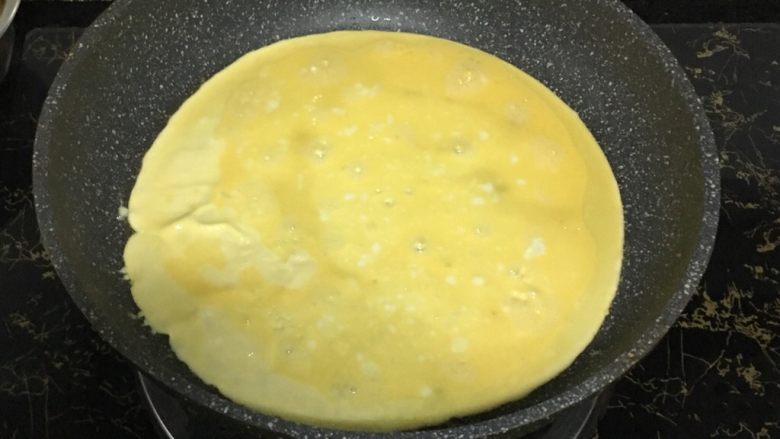 宝宝辅食之虾仁莲藕蛋卷,平底锅烧热,刷一层薄薄的油,倒入蛋液摊成圆形蛋饼,全程小火。