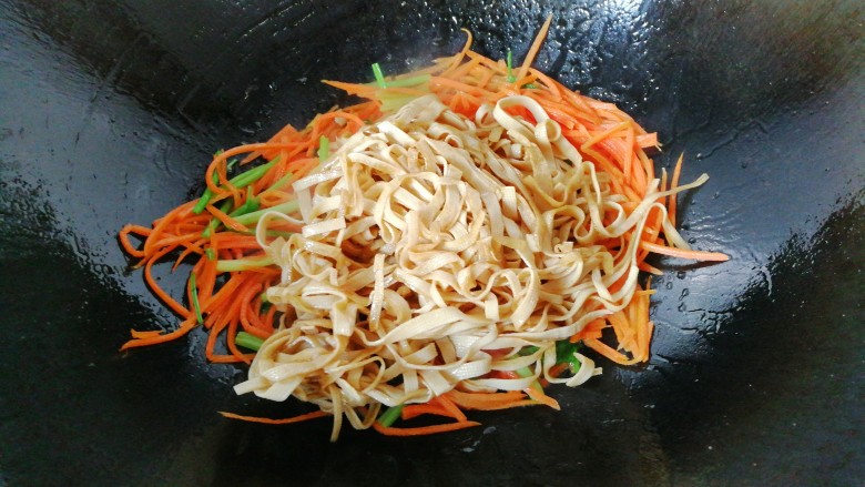 胡萝卜丝炒豆腐皮,再加入豆腐皮一起翻炒均匀;