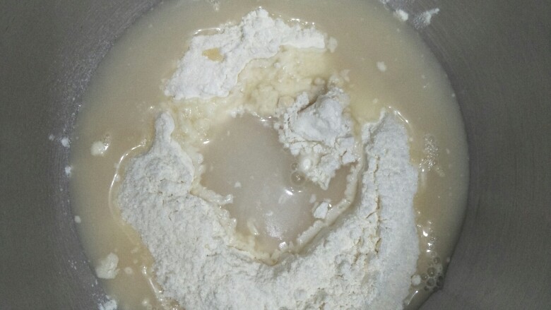 迷你脆皮肠卷,在面粉周围洒入糖,在面粉中间挖个洞放入酵母水后再放入水