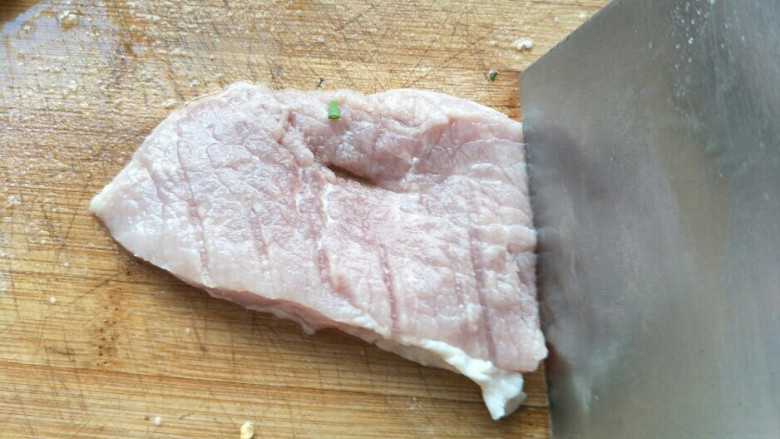 炸猪排,用刀背拍肉,然后轻轻的把肉剁松,横竖和翻面都需要这样加工一下。