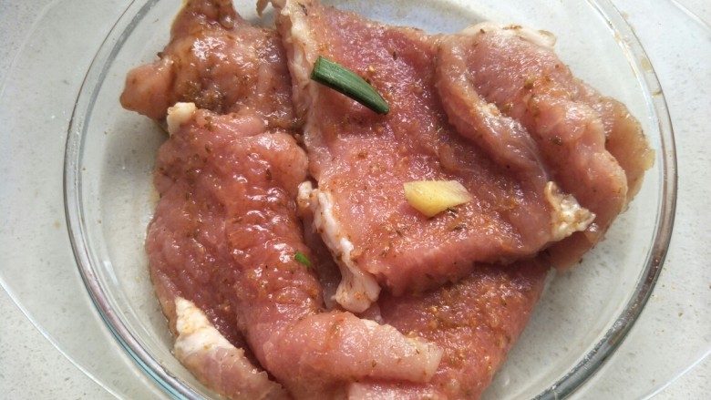 炸猪排,加入葱段和姜片,用手抓匀腌制20分钟左右。