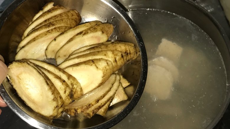 玉米胡萝卜牛蒡汤, 牛蒡外皮用刷子刷干净黑色物质,切片后放入水里。牛蒡皮也含有不少营养成分,而且很薄,用来煲汤牛蒡只需洗净即可。切片为了更好的出味。