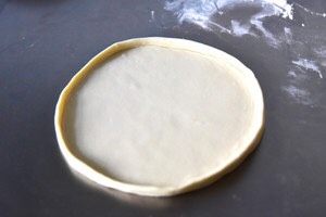 番茄芝士薄底披萨,取一份面团,擀成直径约24cm的原形
用手将面团的边折起
或狂野派的擀法参见步骤9