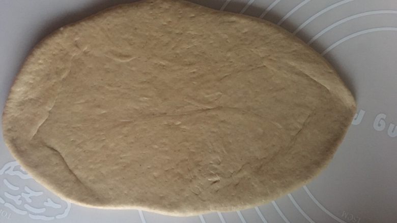 红糖核桃红枣软欧--无比美味,松弛好的面团用手压扁,擀成如图的椭圆状