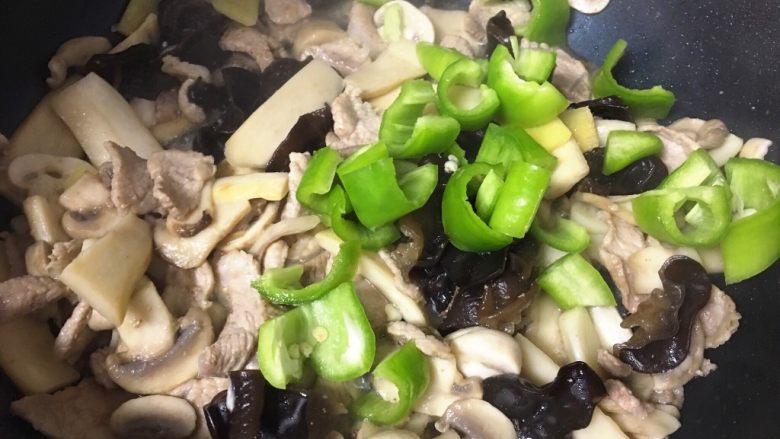 青椒蘑菇炒肉片,放入青椒,翻炒1分钟左右