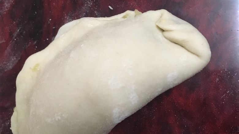 猪肉韭菜盒子,再往上一个角再折一下,继续下去。