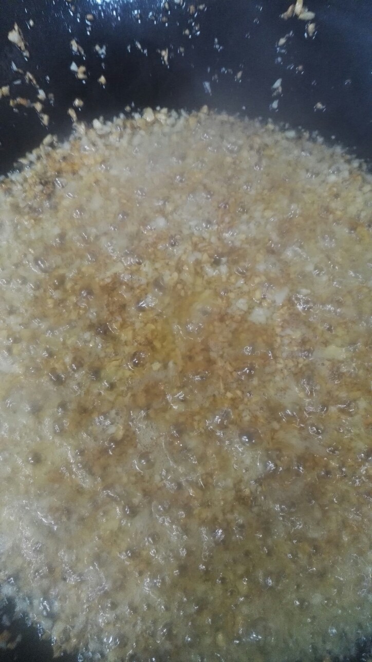 蒜蓉烤生蚝,注意此时油温很热,倒入生蒜末时注意升起的水蒸气,很容易烫伤。