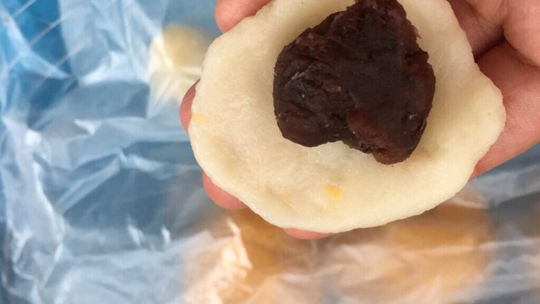 麻糍豆沙南瓜餐包 ,取出麻糍,用擀面杖擀成面片,放入红豆沙。