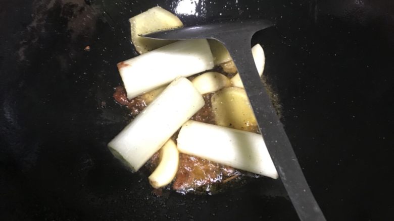 冬季滋补萝卜炖羊排,洗净锅后,热锅后再倒入油(要点:一定要热锅冷油),然后放入1~2匙豆瓣酱、剩下的姜片、大蒜仔等配料,加适量的盐中火爆香约1~2分钟