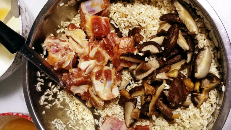 豆瓣排骨糯米饭,蘑菇切丝,排骨和蘑菇倒入糯米中一起搅拌。
