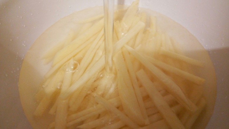 炝薯条,再切丝,要宽一点(炸好会缩小),放入适量清水,泡10分钟,中间可以换几次水,洗去淀粉,捞出沥干水分,这样可使土豆口感更为爽脆