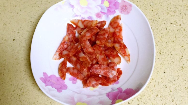 腊肠炒香干,<a style='color:red;display:inline-block;' href='/shicai/ 4536'>腊肠</a>洗净去外衣,纵向切开,在切片。