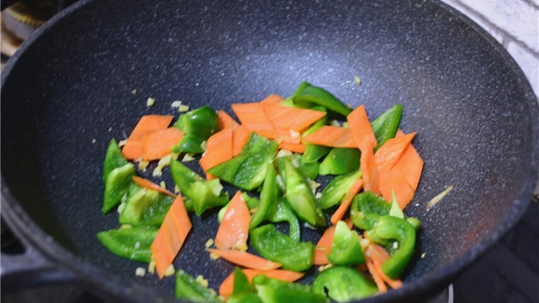 溜肉段,锅中留少许底油，姜蒜爆香，加入青椒，胡萝卜翻炒均匀。