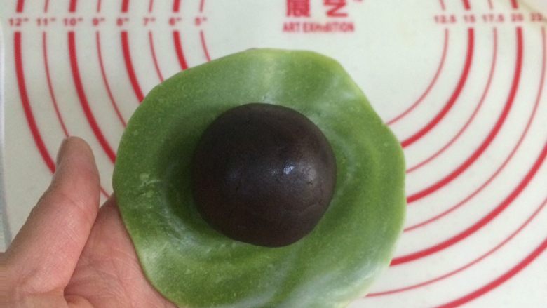 四色螺旋蛋黄酥,把擀开的面皮翻个面,有纹理的那面朝下,放上一枚馅料。