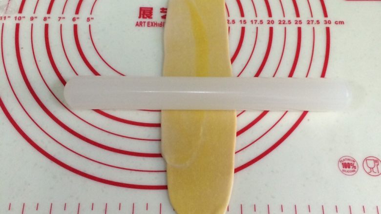 四色螺旋蛋黄酥,取一份静置好的油酥皮,用手压扁,用擀面杖再一次从中间往两头擀开。